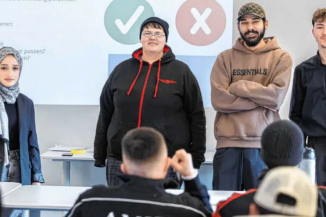 Vier Jugendliche stehen vor einer Klasse