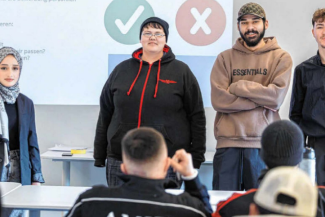 Vier Jugendliche stehen vor einer Klasse