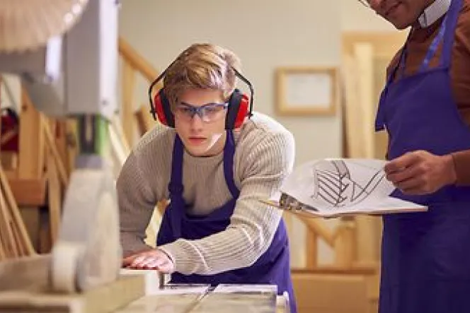 Ein Junge arbeitet an einer Holzbearbeitungsmaschine