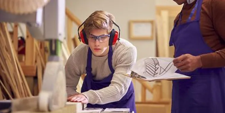 Ein Junge arbeitet an einer Holzbearbeitungsmaschine